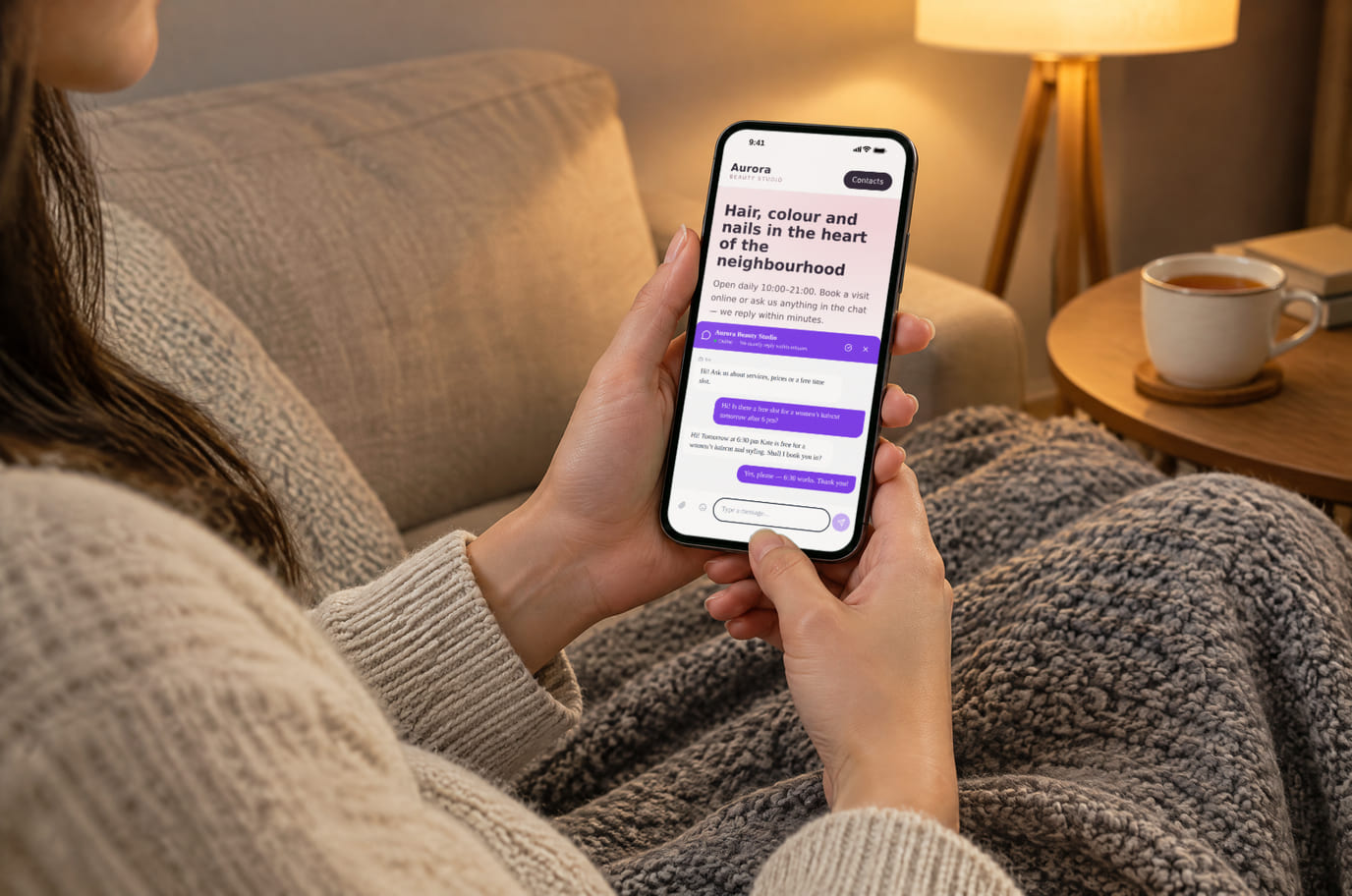 A visitor at home in the evening chats with a salon through the chat on its website on her phone